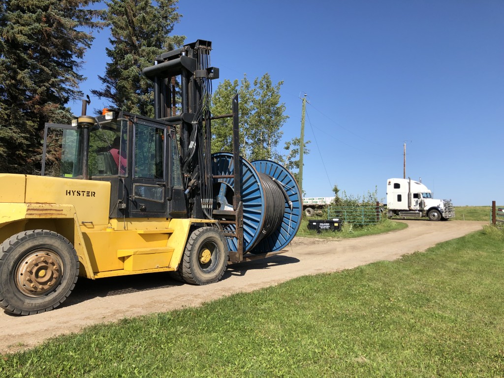 Forklift loading surplus cable reel onto truck